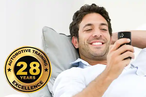 Automotive technician studying for ASE certification on mobile phone